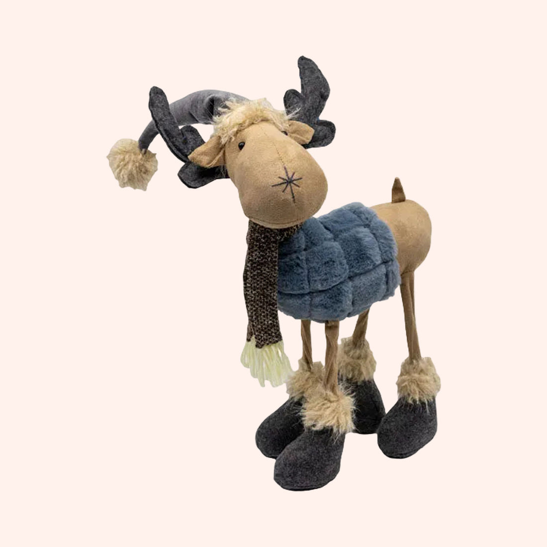 A plush reindeer decoration wearing a gray winter hat with a pom-pom, a brown patterned scarf with cream fringe, a blue faux-fur winter coat, and dark gray felted boots with beige faux-fur trim, shown on a plain background.