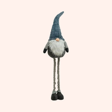 A plush decorative gnome figurine with a tall blue-gray pointed hat, white beard, gray body, striped arms and legs, and black shoes, shown on a plain background.