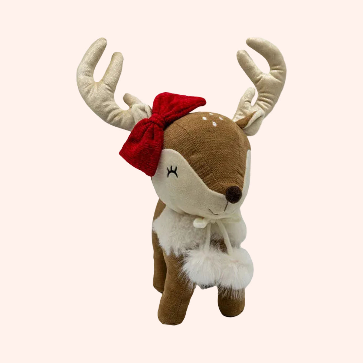 A plush toy reindeer with brown and cream fabric, featuring beige antlers, a red bow, and a white faux-fur collar, shown against a plain background.